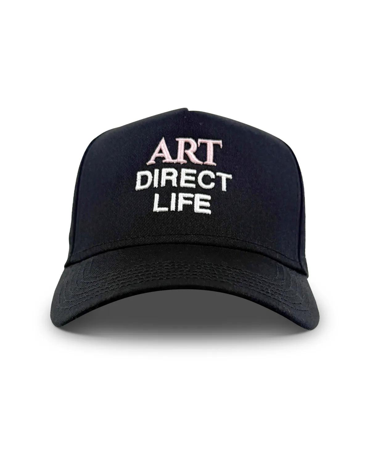 Black baseball cap, front view, with ART embroidered in pale pink above DIRECT LIFE in white